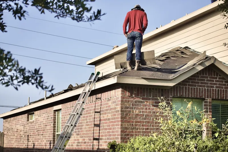 Professional roofer working on a residential roof in Natural Falls